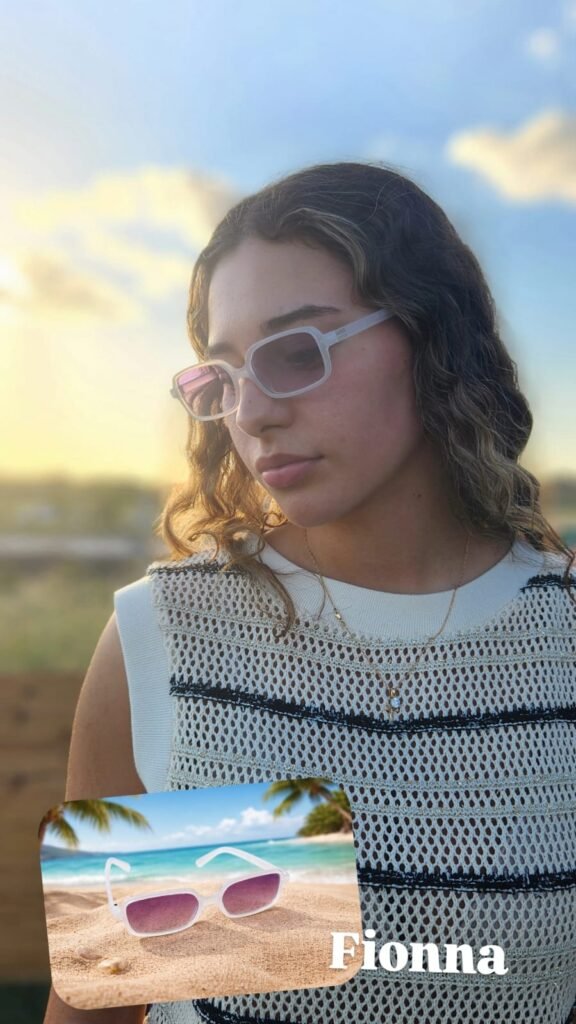 mujer con sueter blanco con rayas negras usando unos lentes de sol.